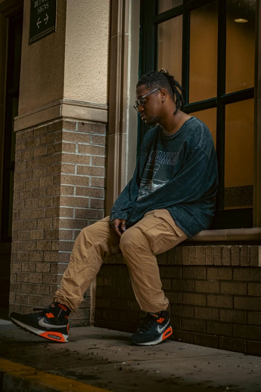 a man is sitting on a ledge in front of a building