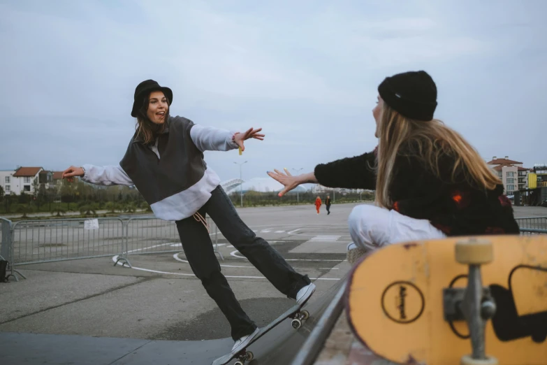 two people sitting on a wall and skateboarding