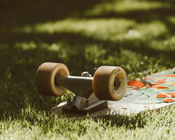 a skateboard with wheels sitting on the grass