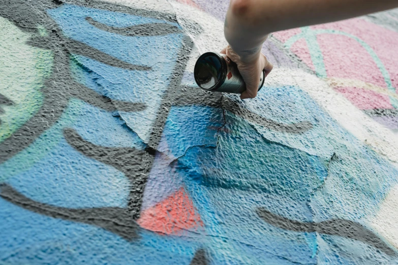 a person painting a mural with rollers on it