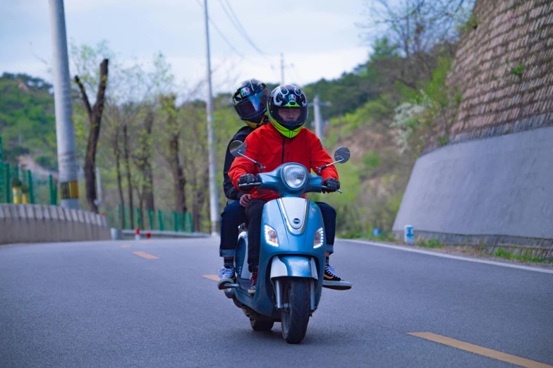 a man and a woman are riding a scooter on a street