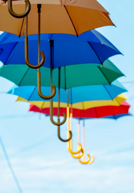 several umbrellas suspended by ropes in the sky