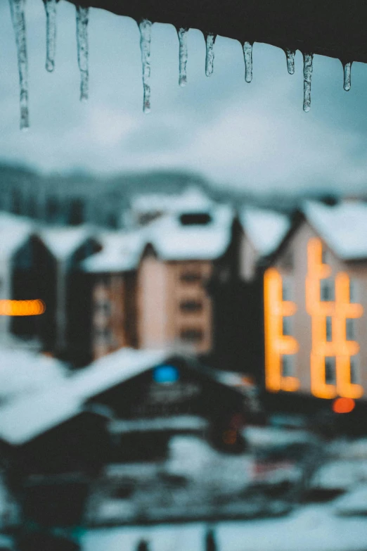 there are icicles hanging from a roof over looking some houses