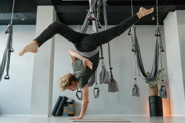 a man does a handstand in a studio