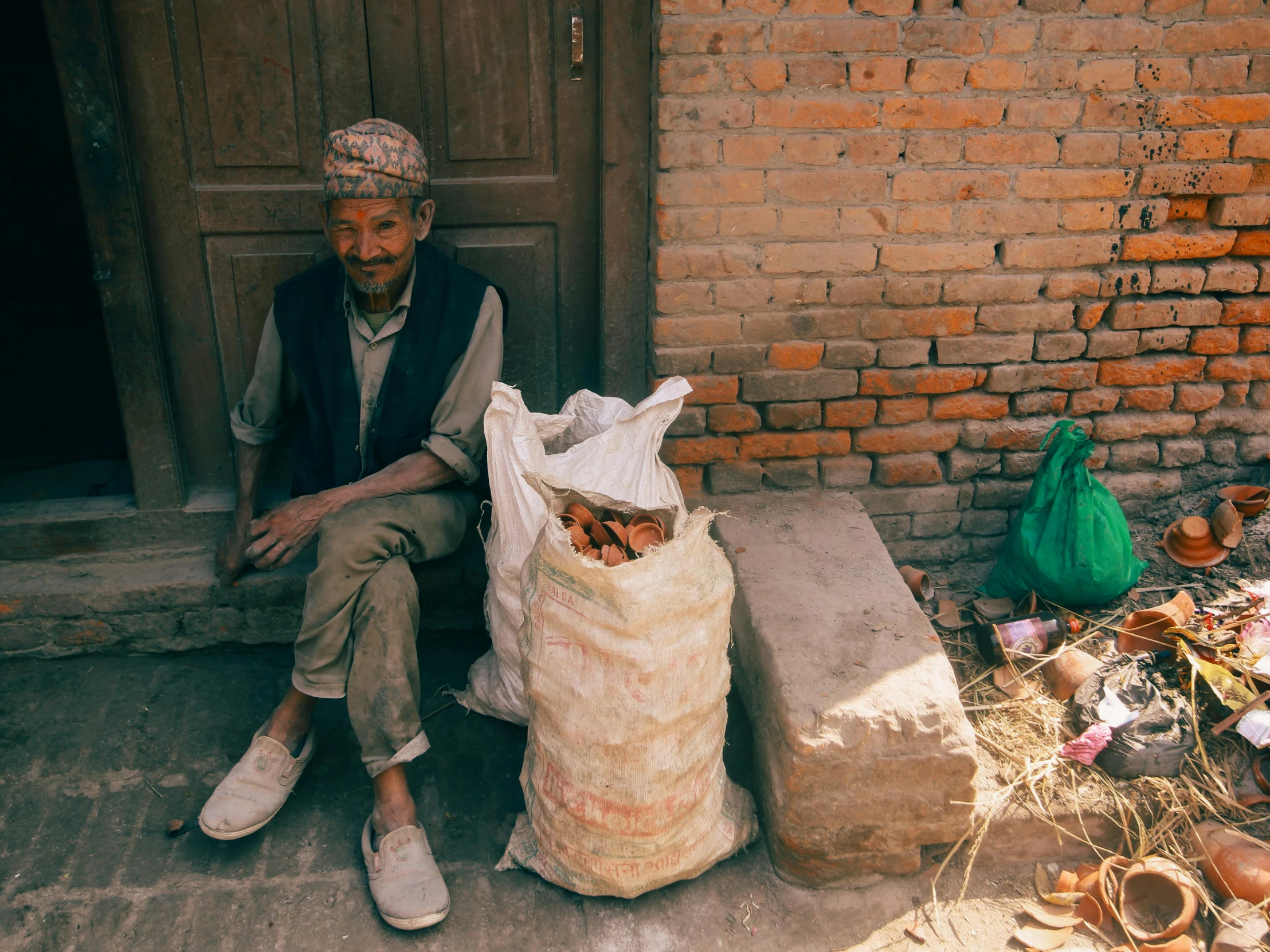 a man sitting on a porch with a bag on the ground