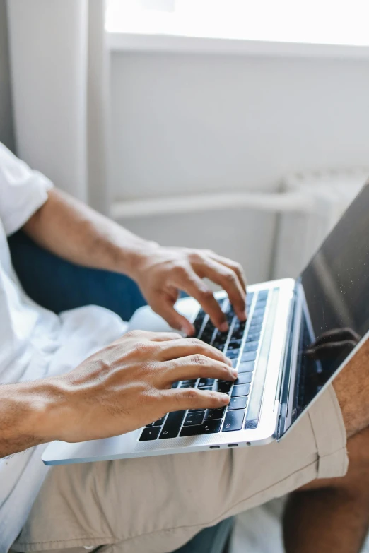 a person is using a laptop on their lap