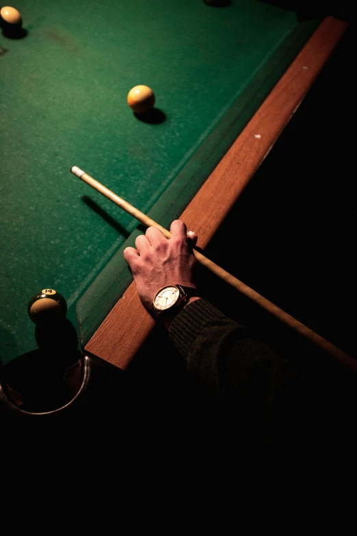 the man is leaning over the pool table