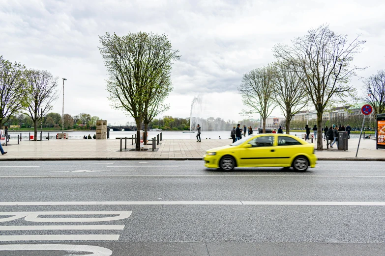 a yellow car passing by on the road