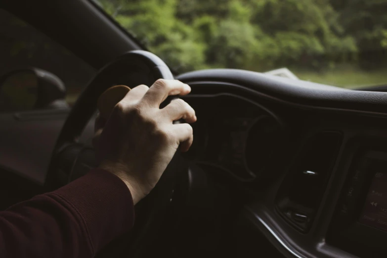 someone using their hand to drive in a car