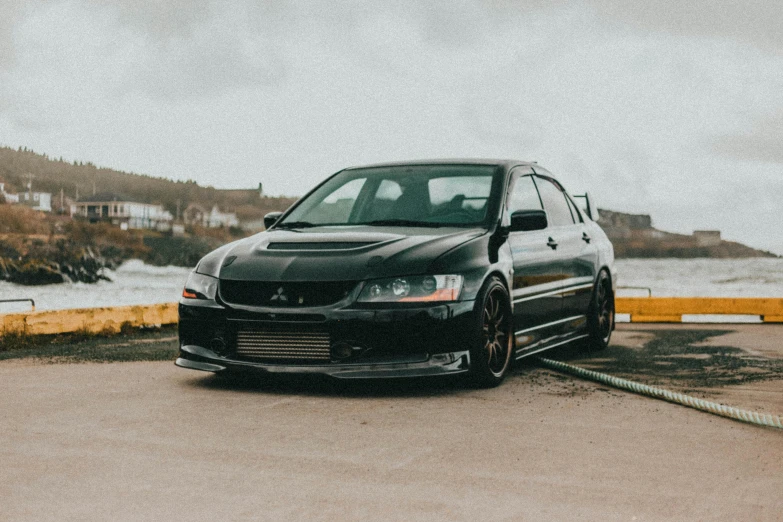 a car parked on top of a road by water