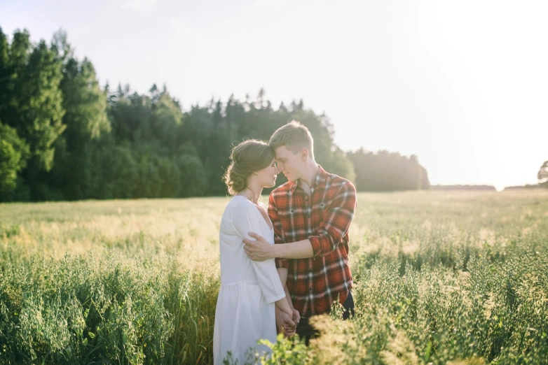 a man and woman are standing in a field