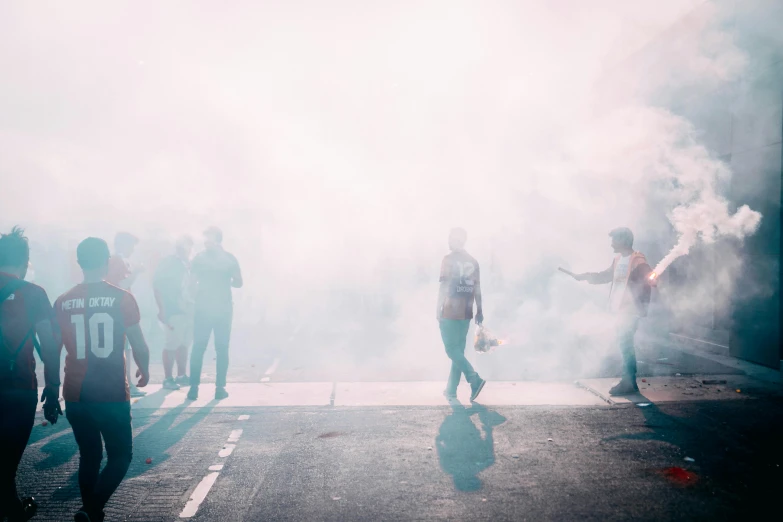 a group of people that are standing around some smoke