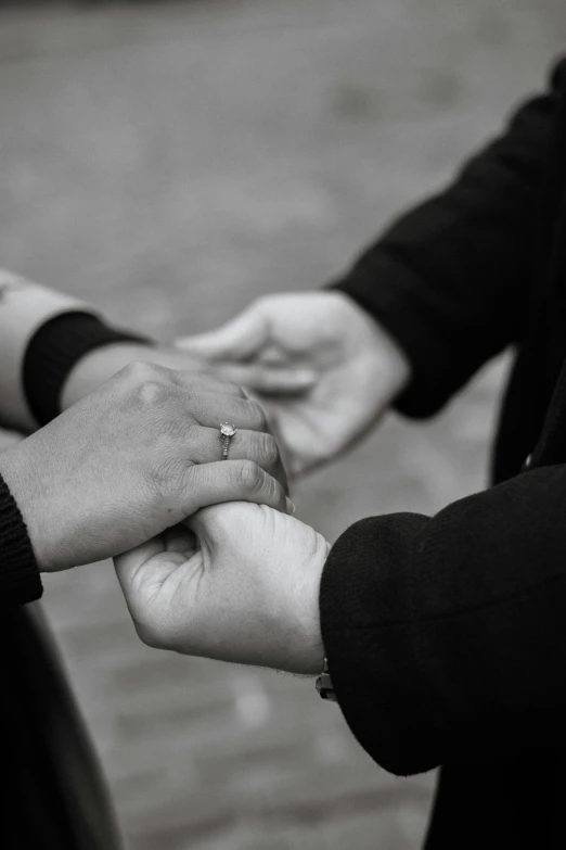 closeup of the bride and grooms hands holding each other's hands