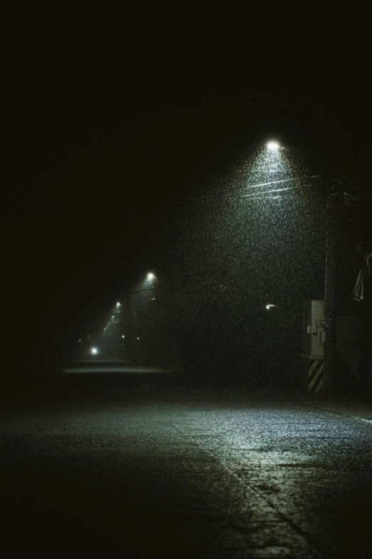 street lights shine in the dark and dreary evening rain