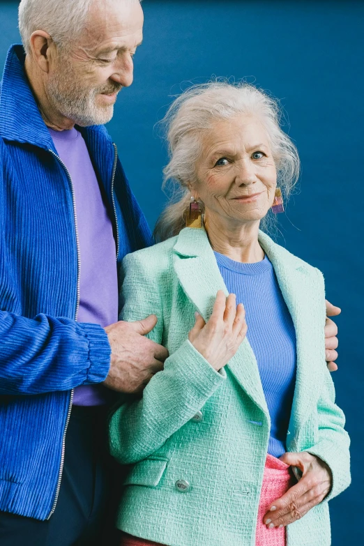 an older man and woman are standing outside