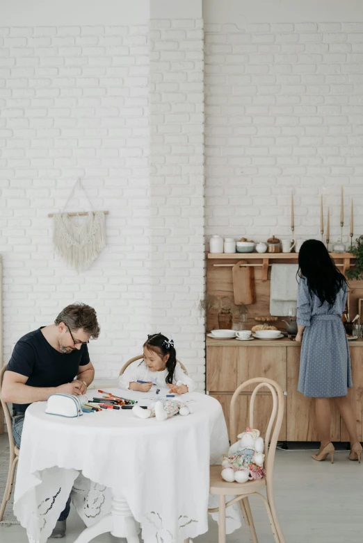 two people sit at a table near a brick wall