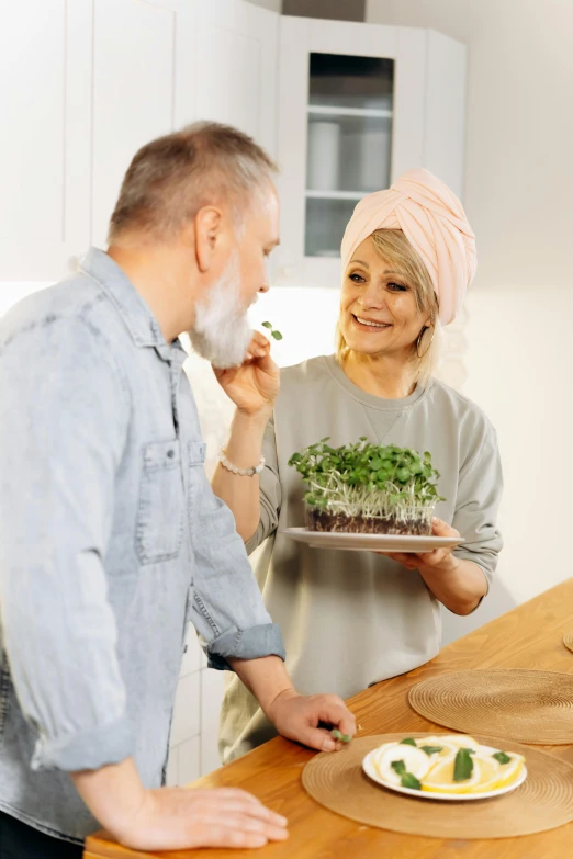 a couple holds a tray with a plant on it