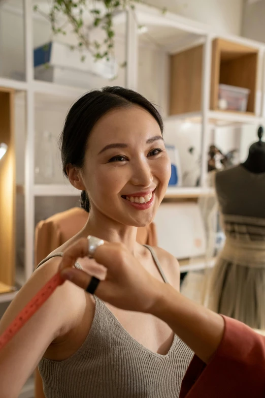 a woman is smiling and adjusting the collar on her shirt