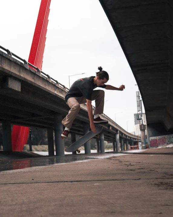a young man is skate boarding in front of a bridge