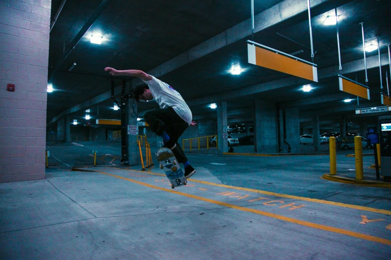 the man in the white shirt is jumping on his skateboard