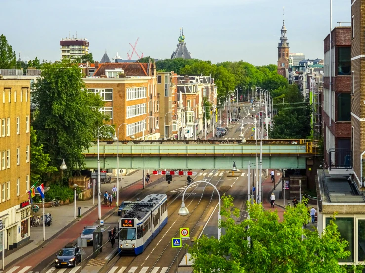 a train traveling past tall buildings next to a bridge