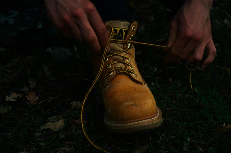 a man is tying his boots with the laces