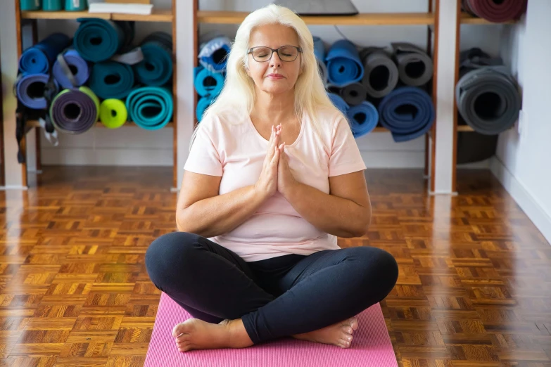 a woman doing yoga with her hands folded up