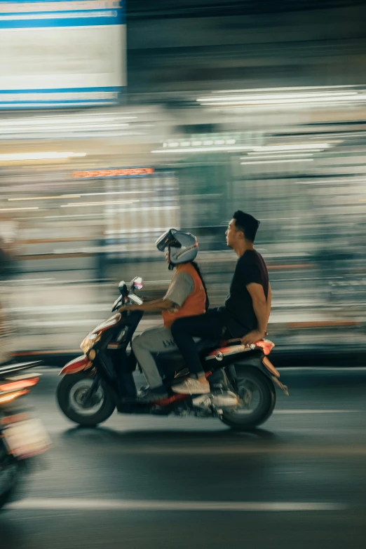 two people are riding on a motorcycle on the road