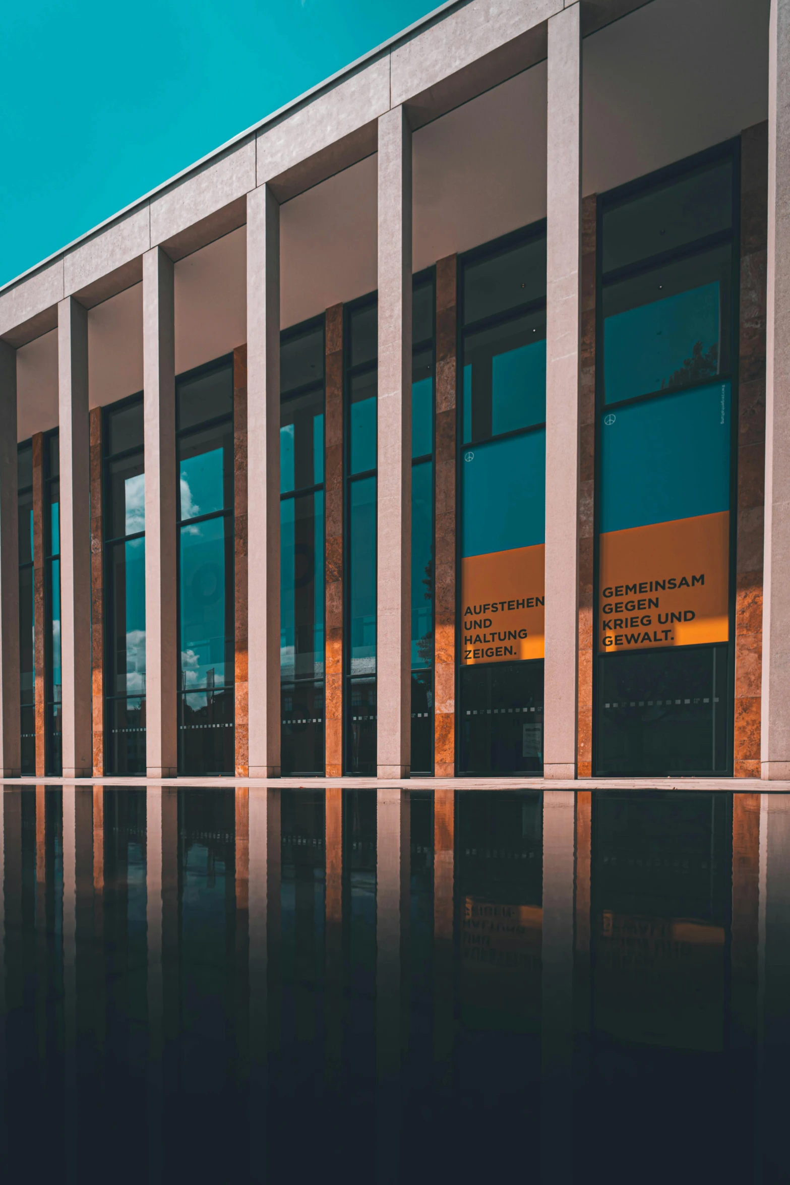 an office building with glass windows and sky in the background