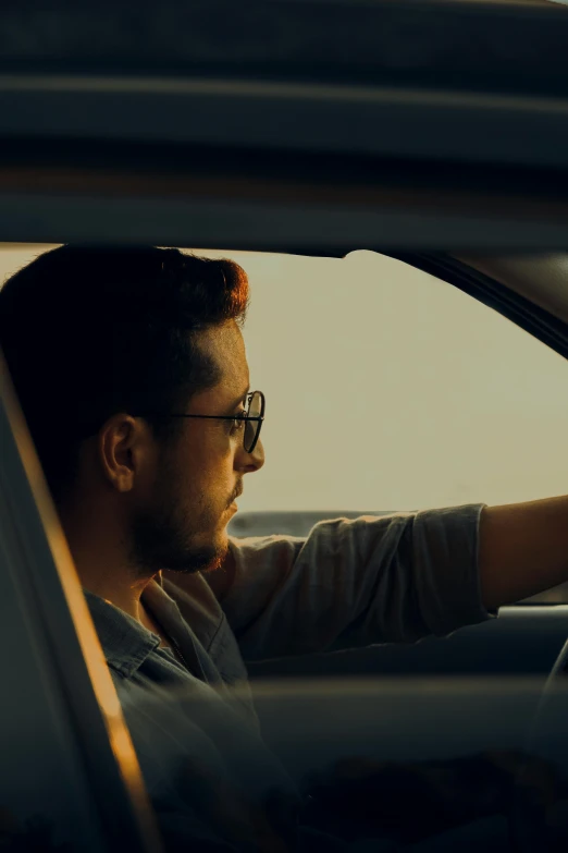 a man driving his car, and looking out the window