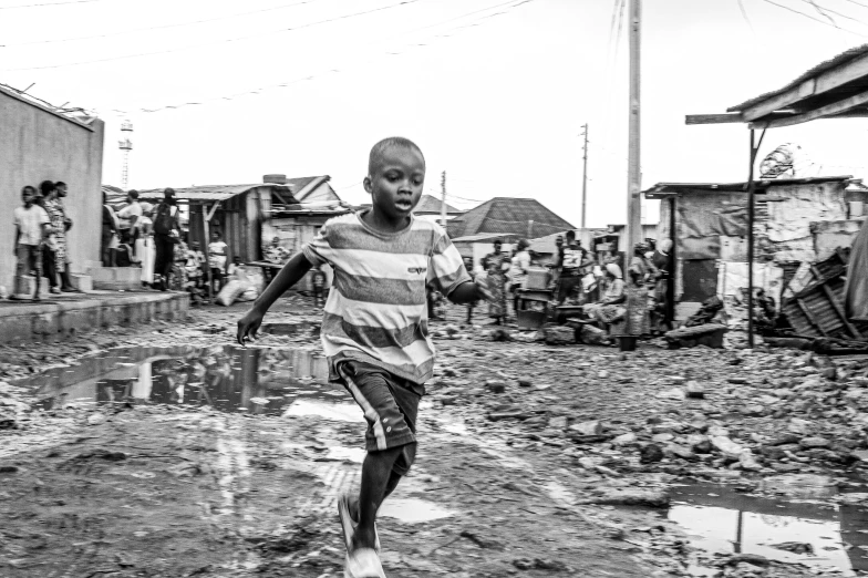 children play on mud on a dirty street