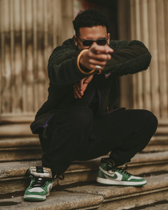 a man sitting on steps with his hand holding a gun