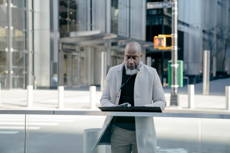 an elderly man standing with his laptop computer