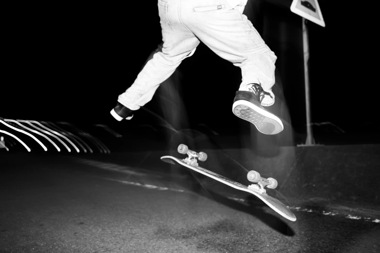 black and white pograph of a person jumping on a skateboard