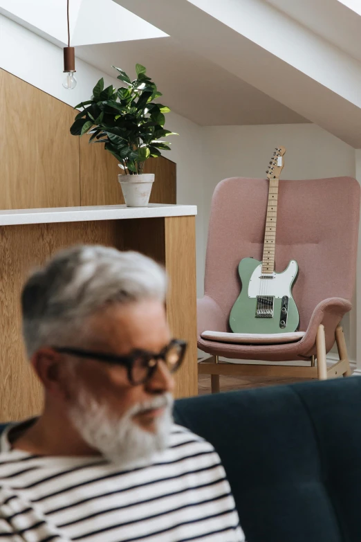 an older man is sitting down in front of a guitar