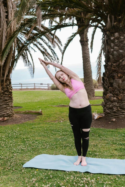 a woman doing yoga in a park