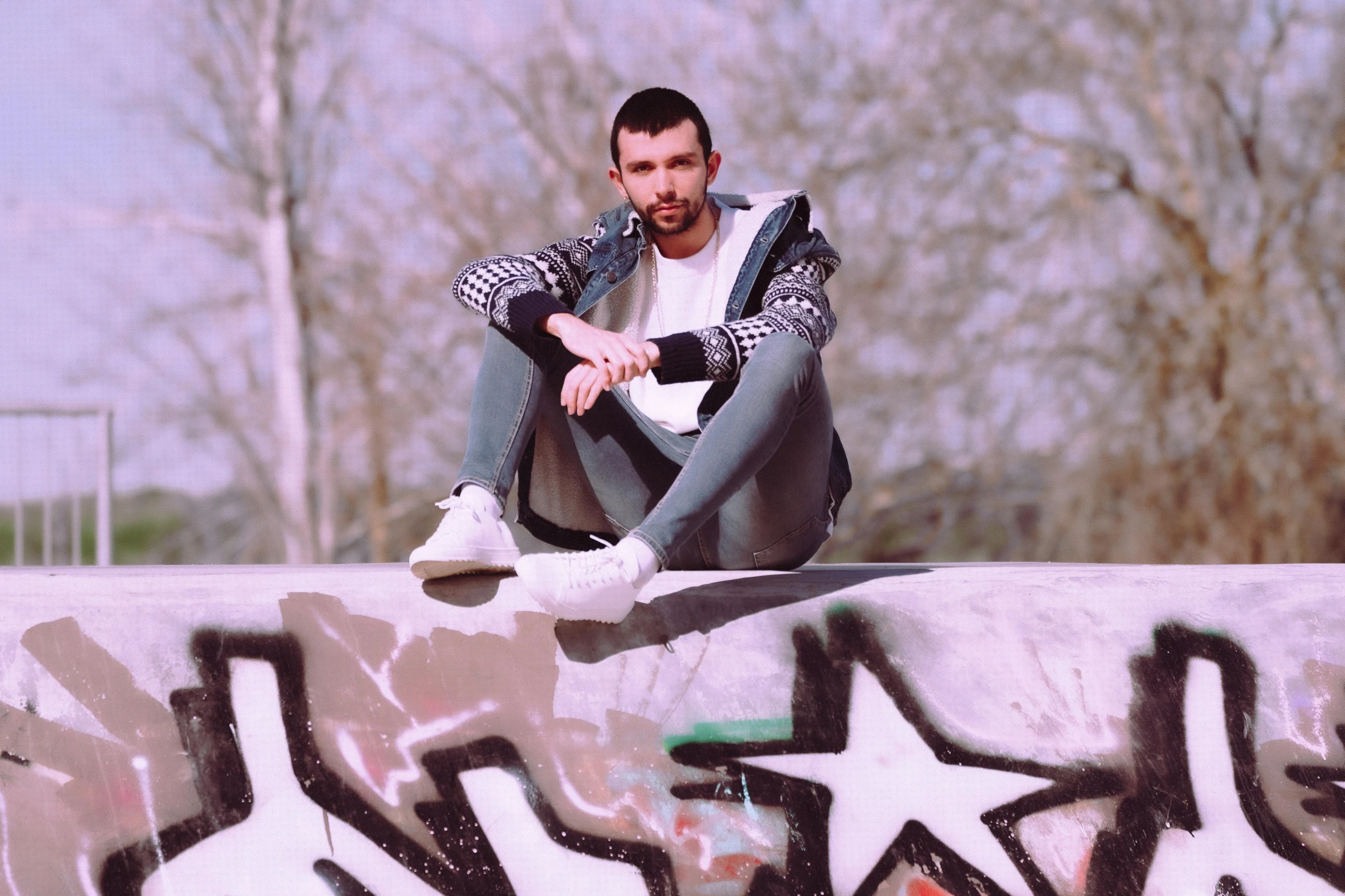 a man sits on a skateboard, doing tricks