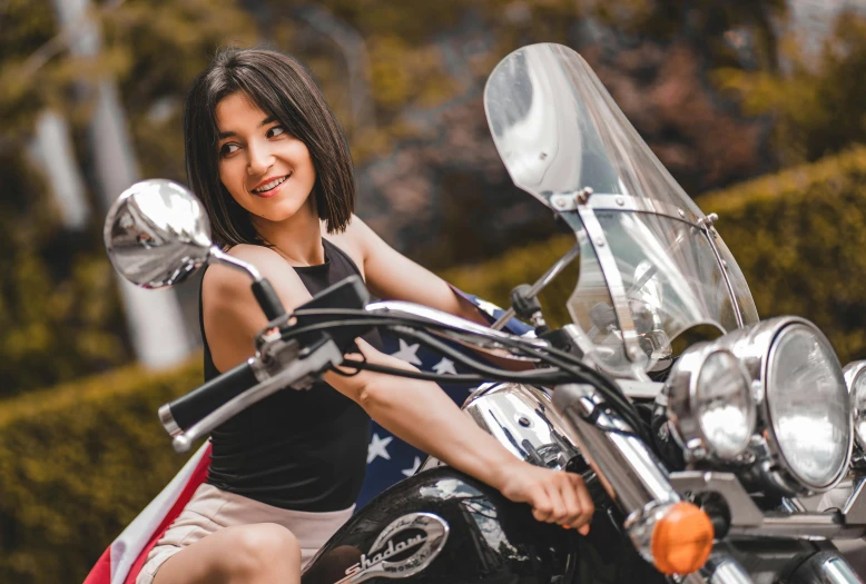 a woman that is sitting on the side of a motorcycle