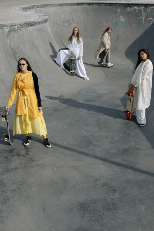 four girls standing around in a skateboard park