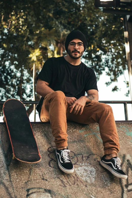 a man sitting on top of a skateboard ramp