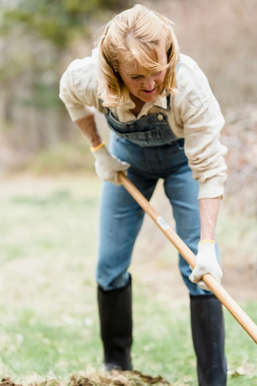 a woman is digging in the ground with her shovel