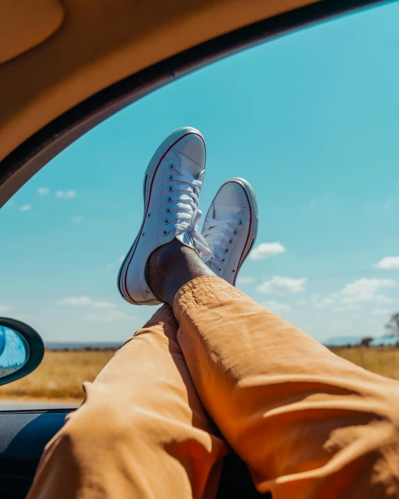 a person in sneakers is shown sitting in the back seat