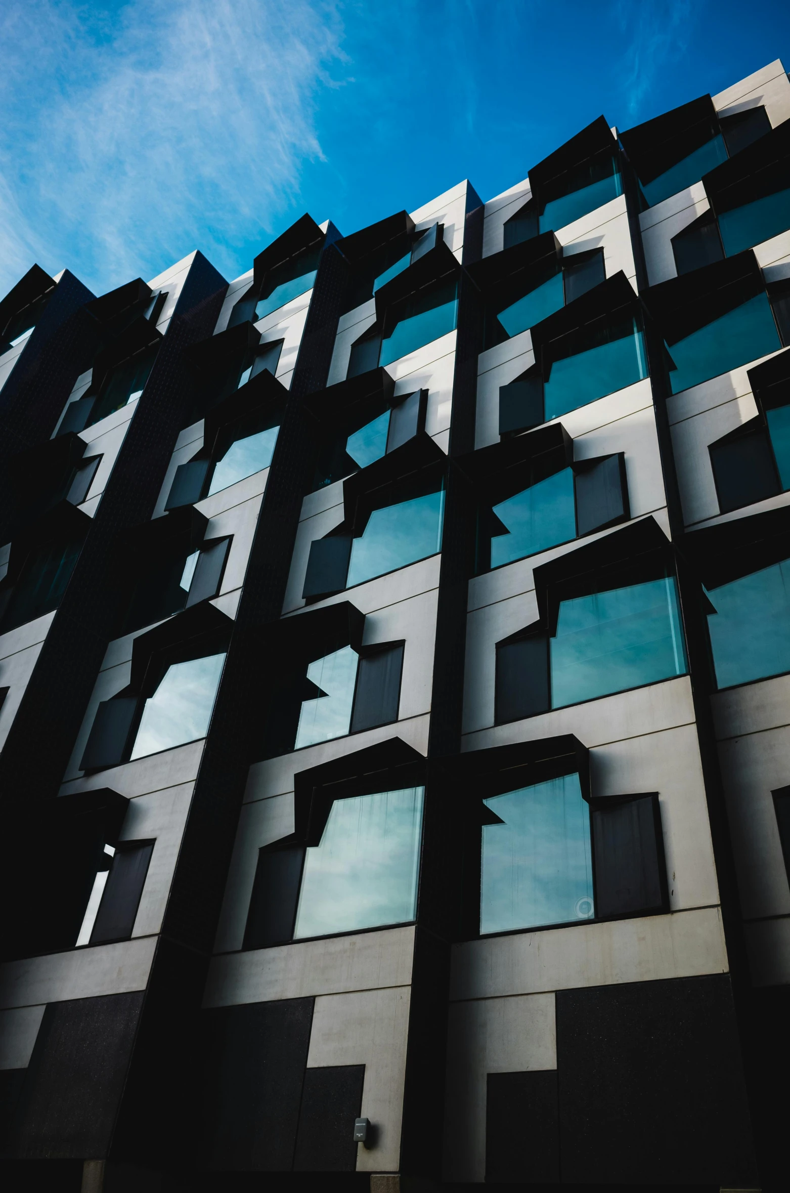 the corner view of a building with windows and sky in background