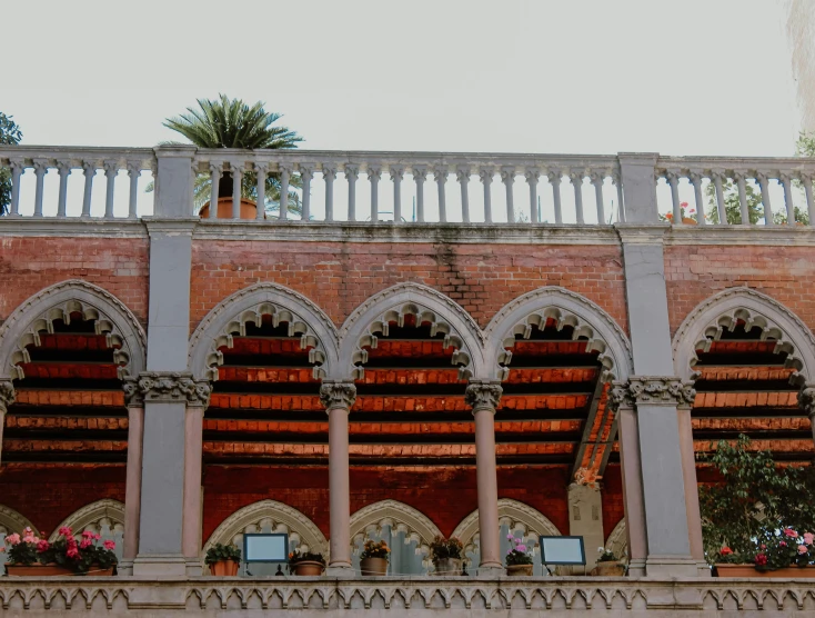 several brick structures with arches above and flowers growing on them