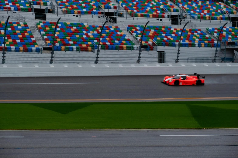 a race car driving past a grassy green field