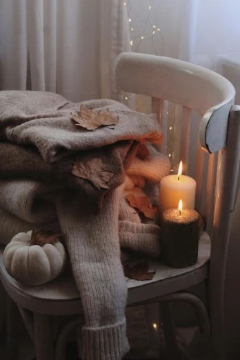 a cozy chair with blankets and a candle