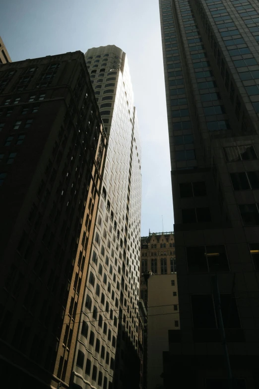 looking up at tall buildings against a clear sky