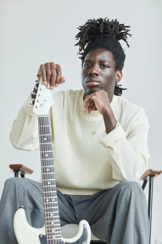 a man sits in a chair with a guitar