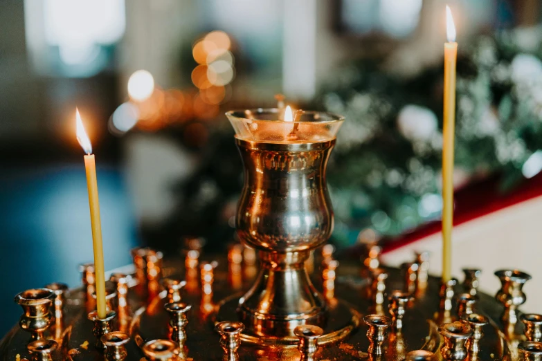 several lit candles sitting on an antique metal plate