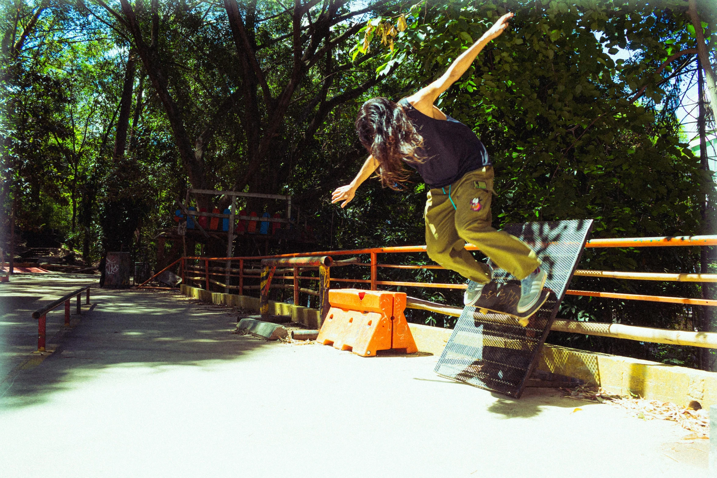 the boy in the black t - shirt is doing a trick on his skateboard